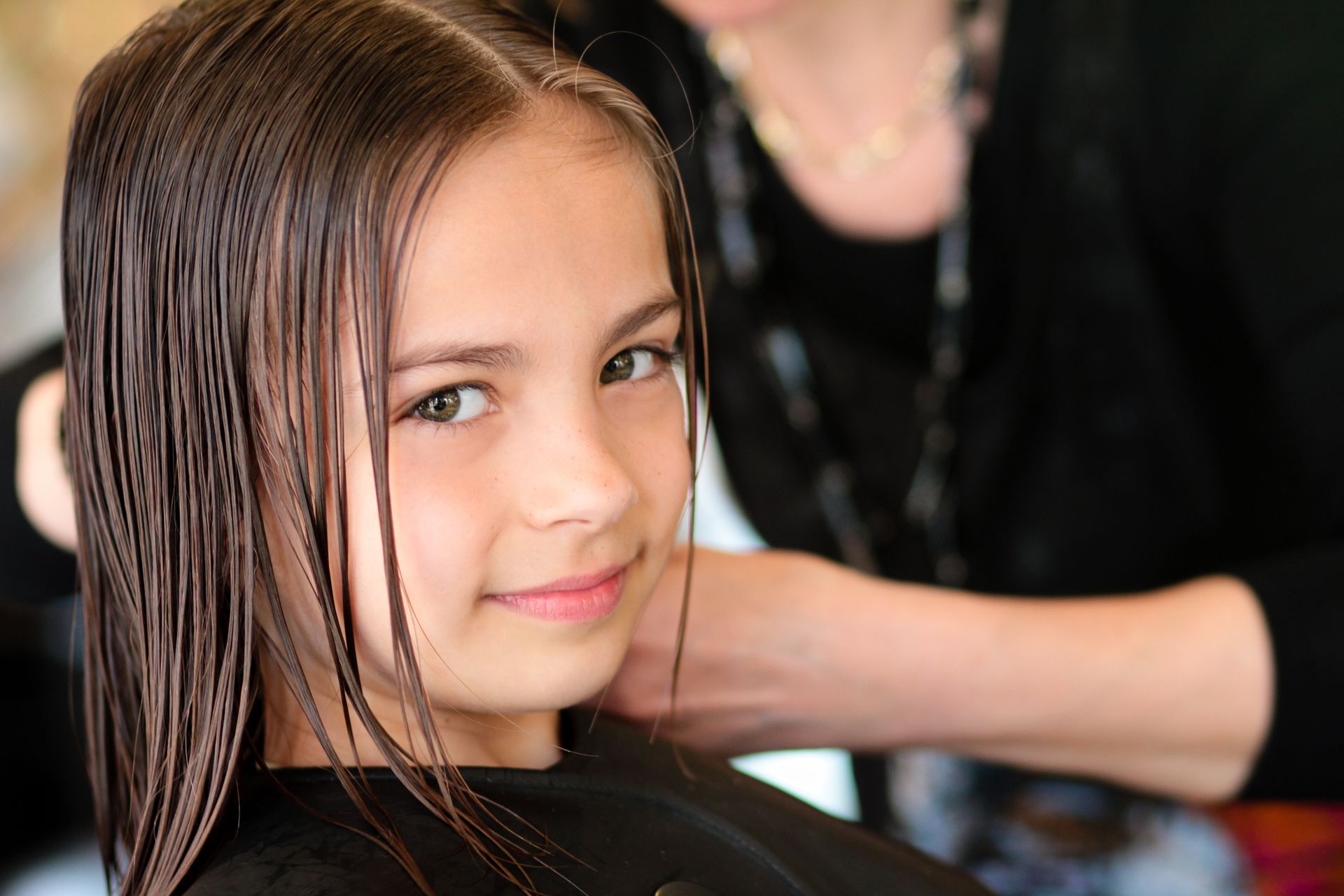 Petite fille avec les cheveux mouillés regardant en direction de l'objectif
