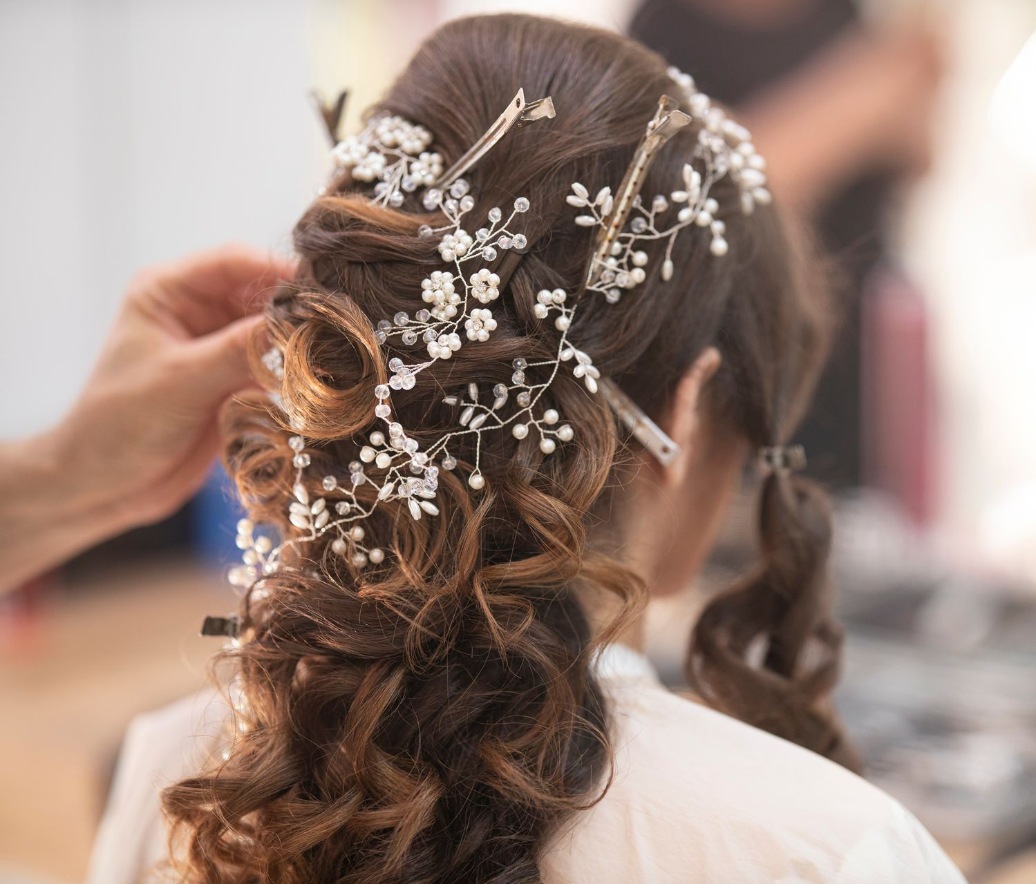 Chignon de mariée avec barrettes et perles dans les cheveux