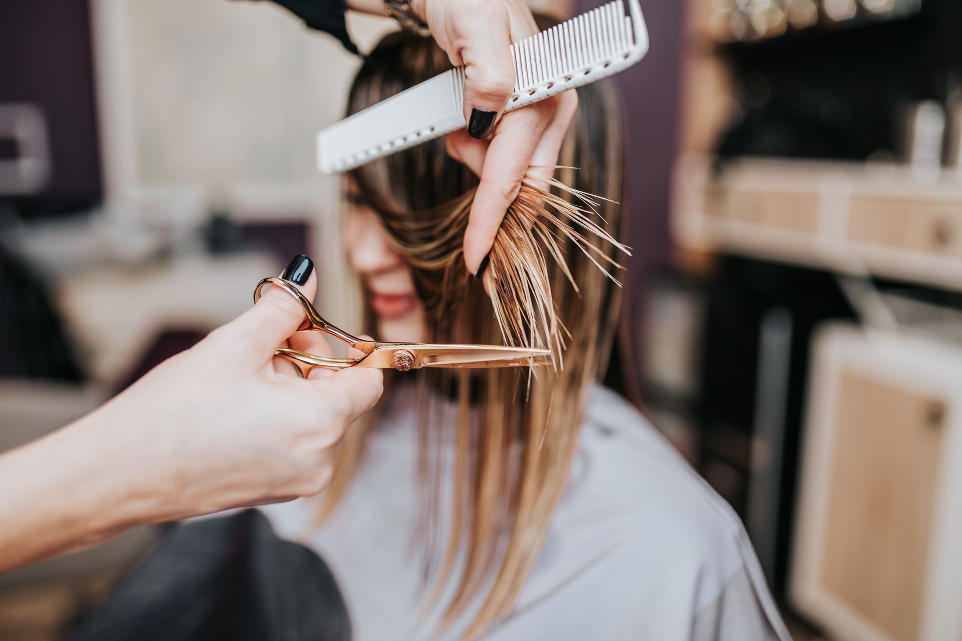 Mains tenant des ciseaux et un peigne réalisant une coupe de cheveux 