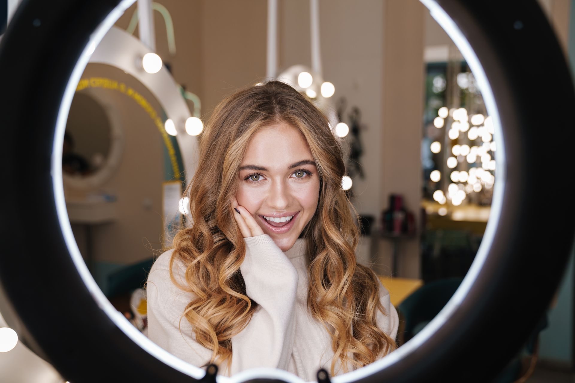 Femme souriant en admirant sa coiffure dans un miroir