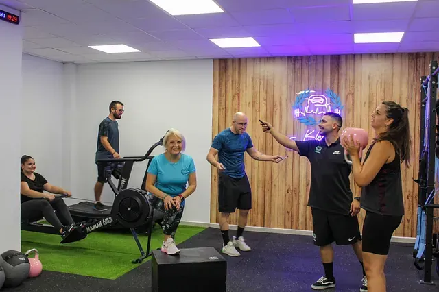 Un grupo de personas están de pie en un gimnasio hablando entre sí.