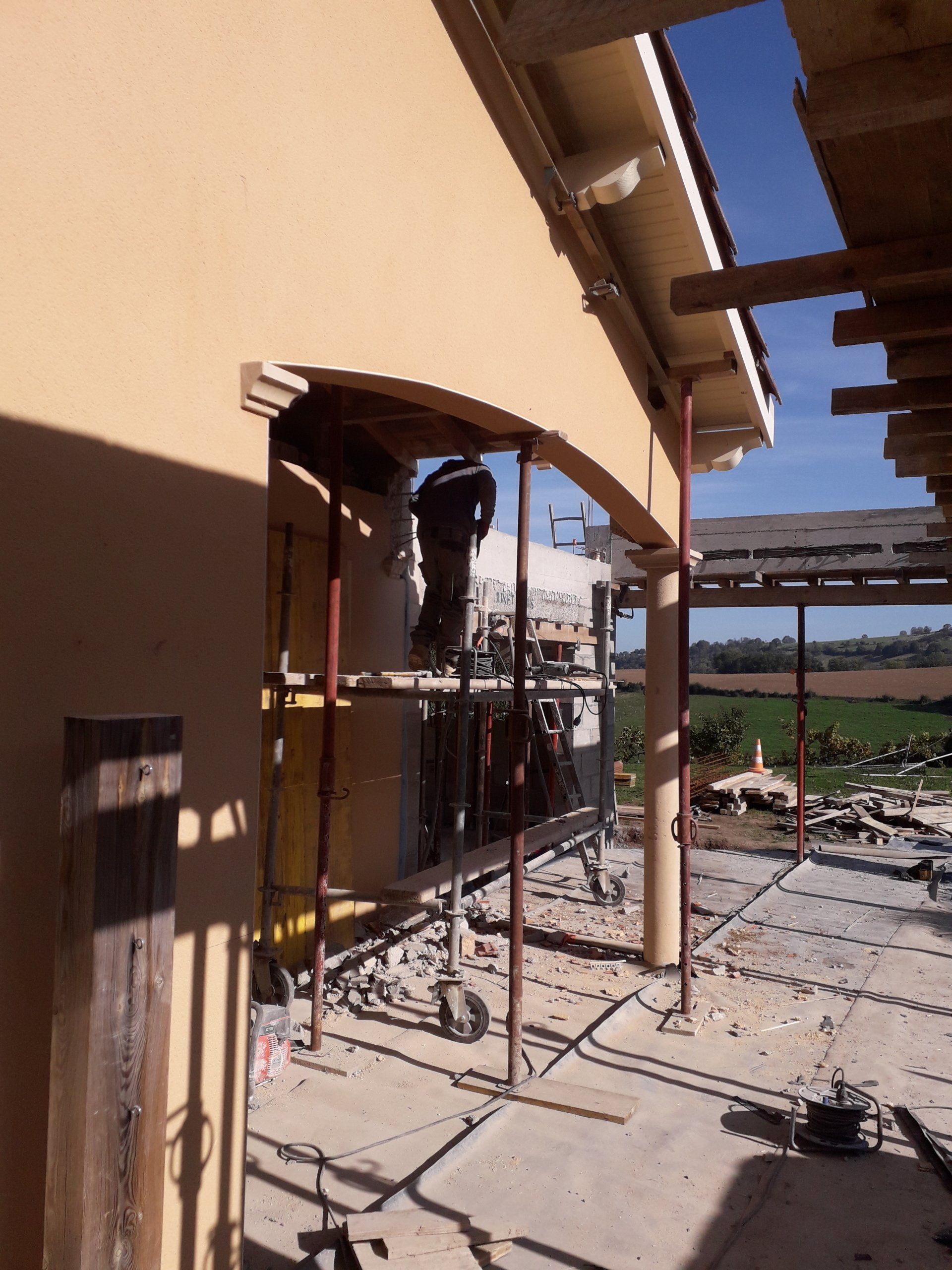 Travaux d'extension d'une maison avec une personne sur un échafaudage