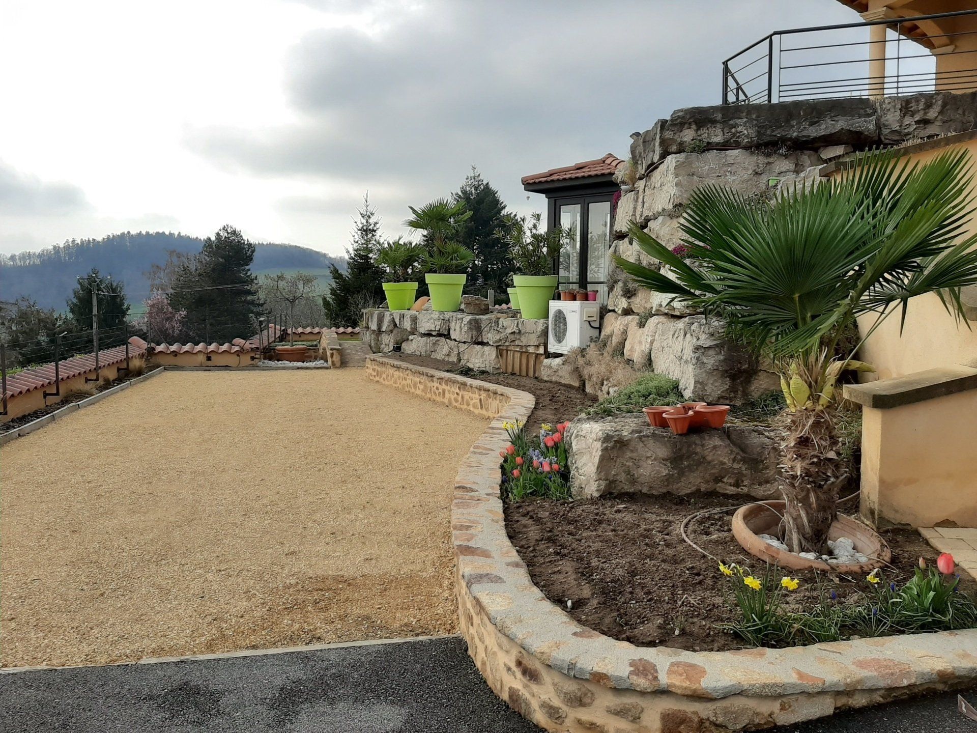 Mure en pierres de pays avec terrasse