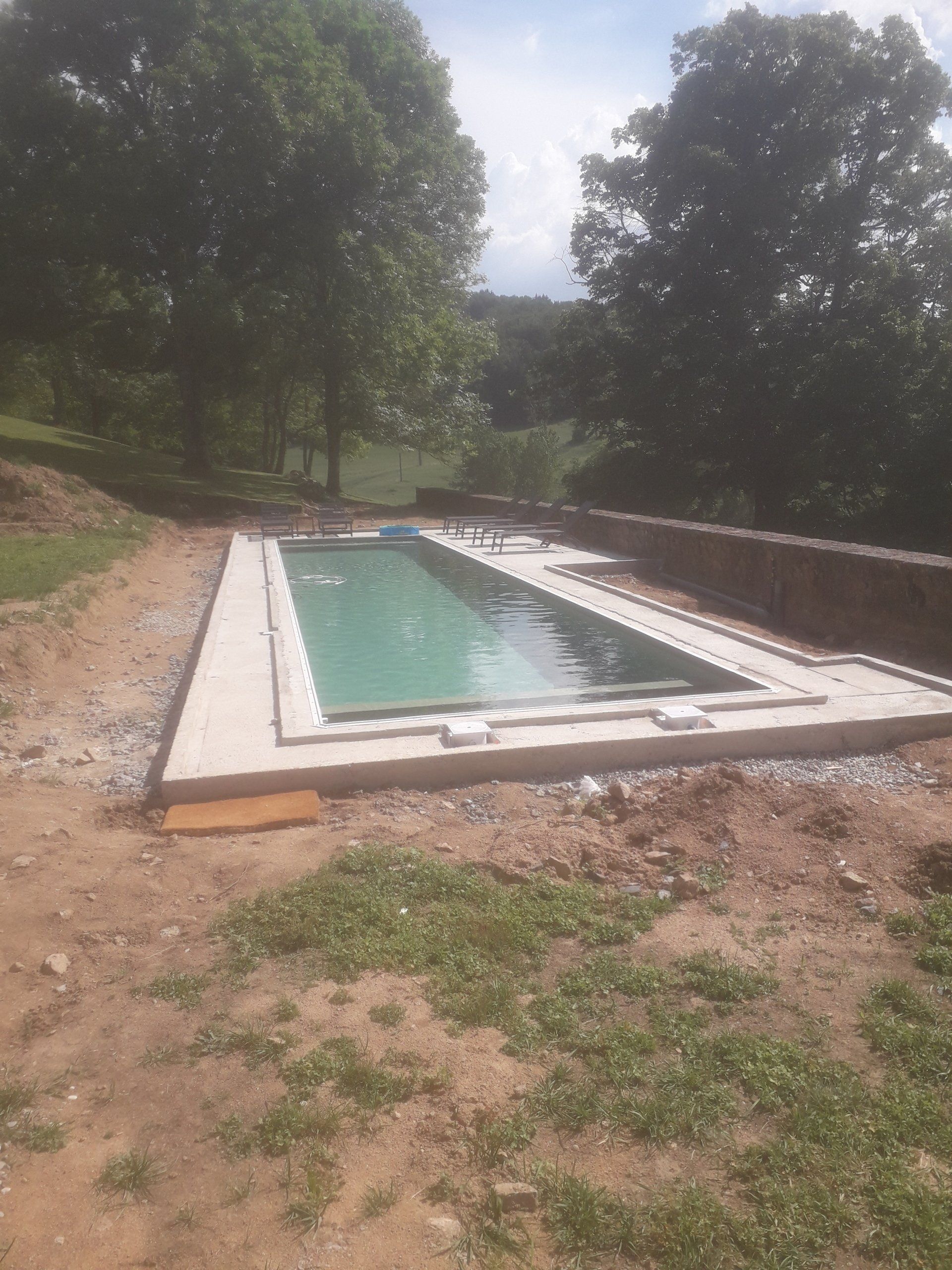 Piscine en béton rempli d'eau dans un terrain