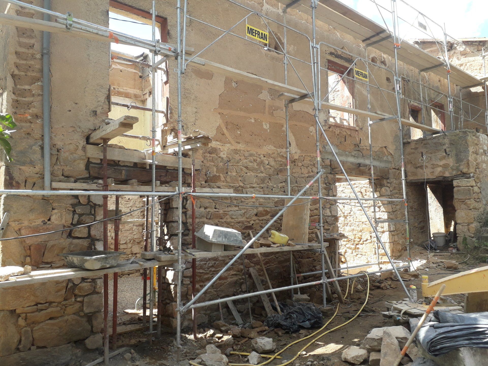 Échafaudage sur un mur en pierres en train d'être rénové