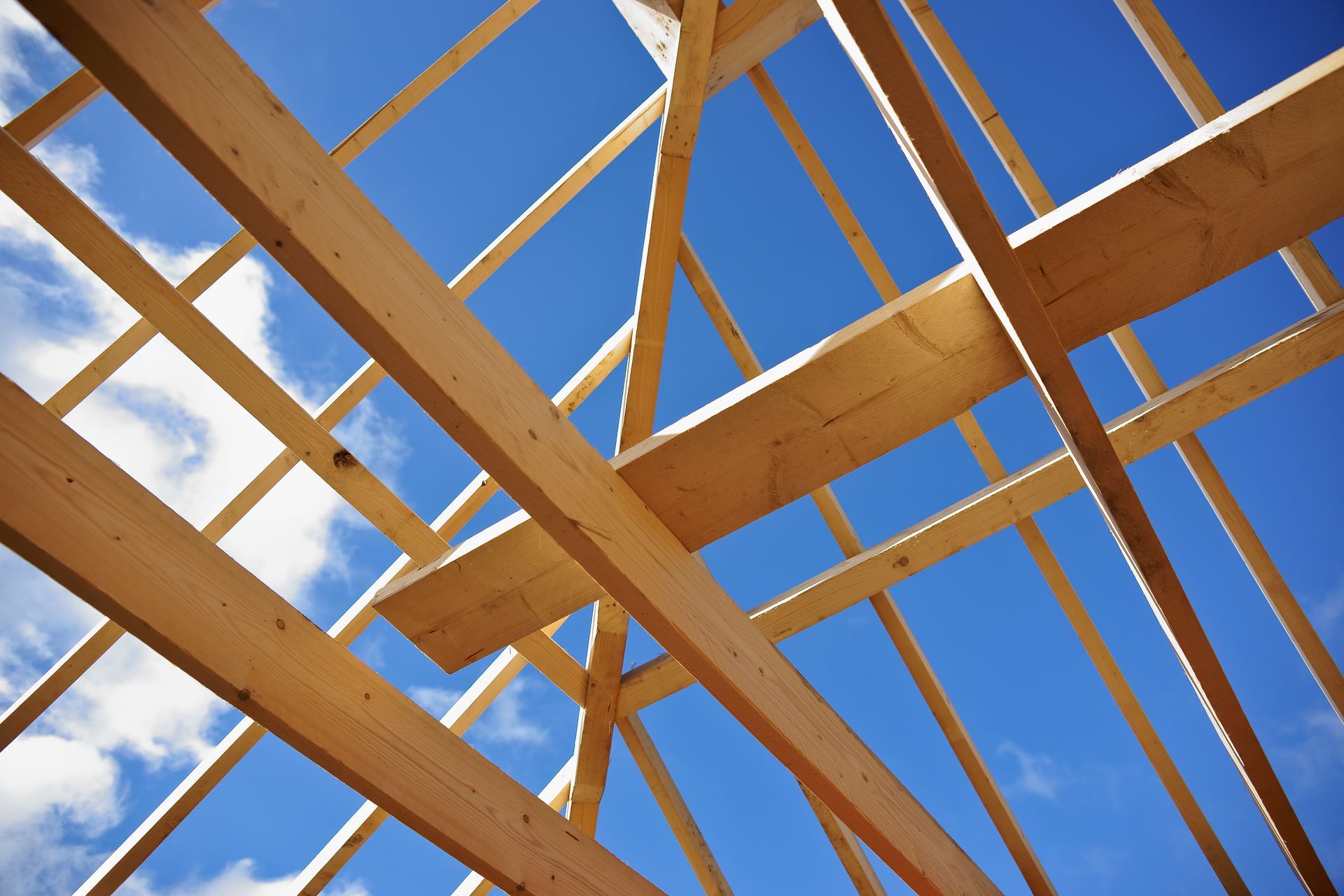 Toiture en bois se détachant sur un ciel bleu clair parsemé de nuages