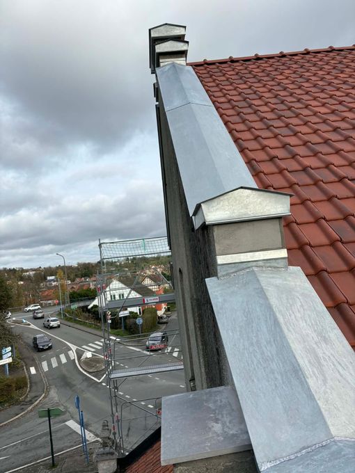 Toiture en construction avec contreplaqué apparent, tuyaux de ventilation et arrière-plan montagneux
