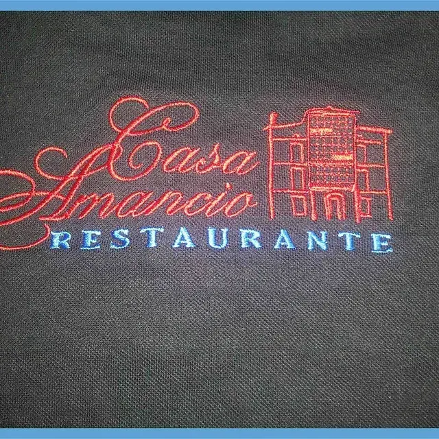 Una camisa negra con un logo bordado en rojo para Casa Amancio Restaurante