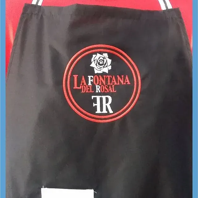 Un delantal negro con la Fontana del Rosal bordada.