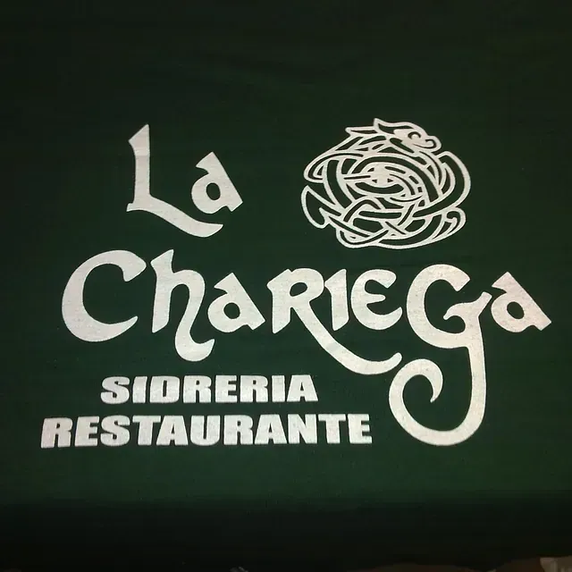 Un logotipo de La Chariega reposa sobre una tela verde.