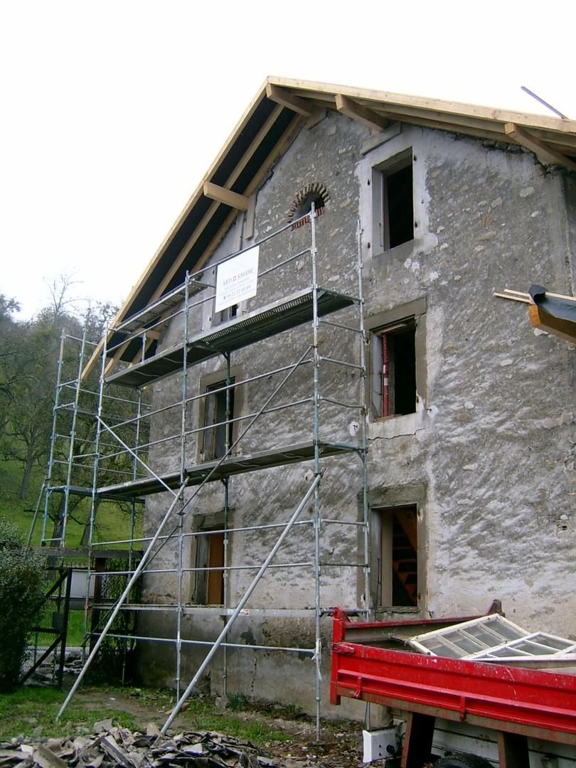 Échafaudages pour la remise en état d'une façade de maison en pierres