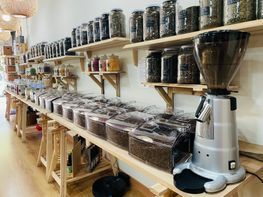 Un molinillo de café está sobre una mesa de madera en una tienda.