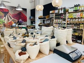 Una tienda llena de bolsas de especias y una báscula.