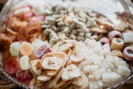 Un recipiente de vidrio lleno de una variedad de frutas secas y nueces.