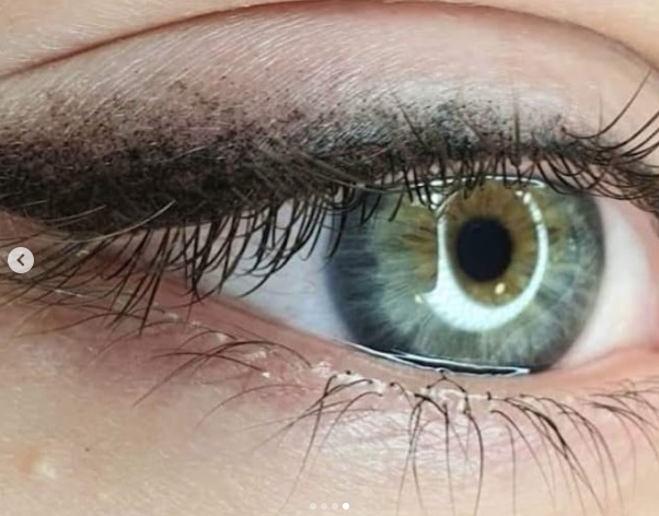 Un primer plano del ojo verde de una mujer con pestañas largas.