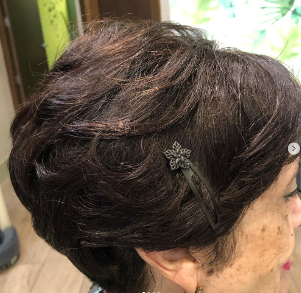 Una mujer con cabello corto y castaño lleva una diadema con una mariposa.