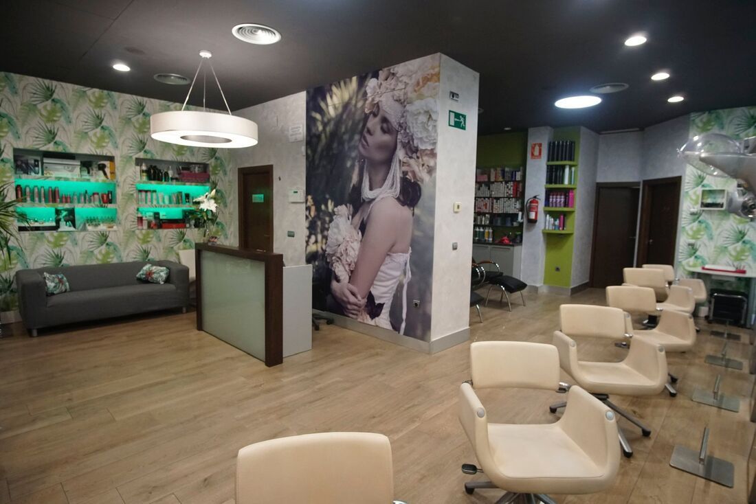 Un salón con un sofá, sillas y un mural de una mujer en la pared.