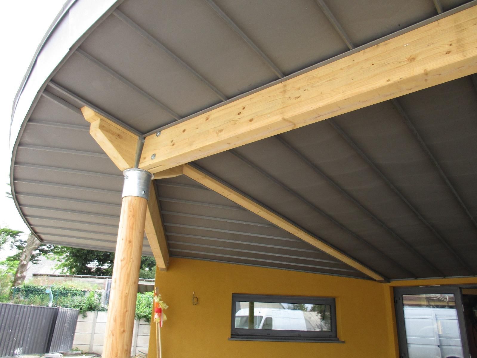 Structure en bois et métal avec un toit incurvé. Toiture grise, mur jaune et poteau en bois.