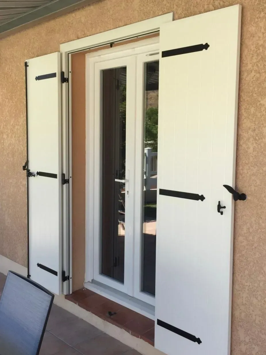 Une fenêtre avec des volets blancs