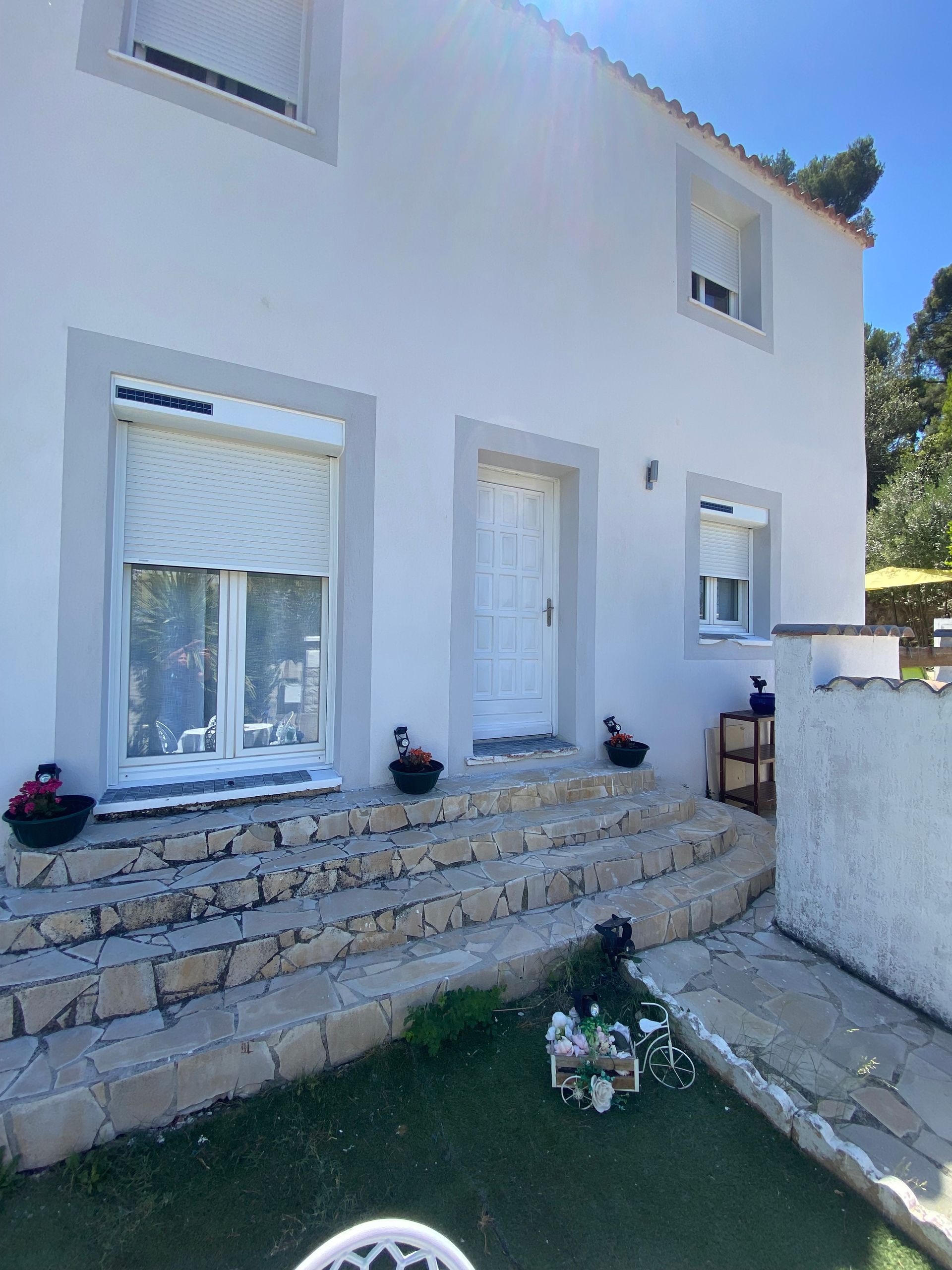 Une façade avec des volets roulants blancs à demi fermés