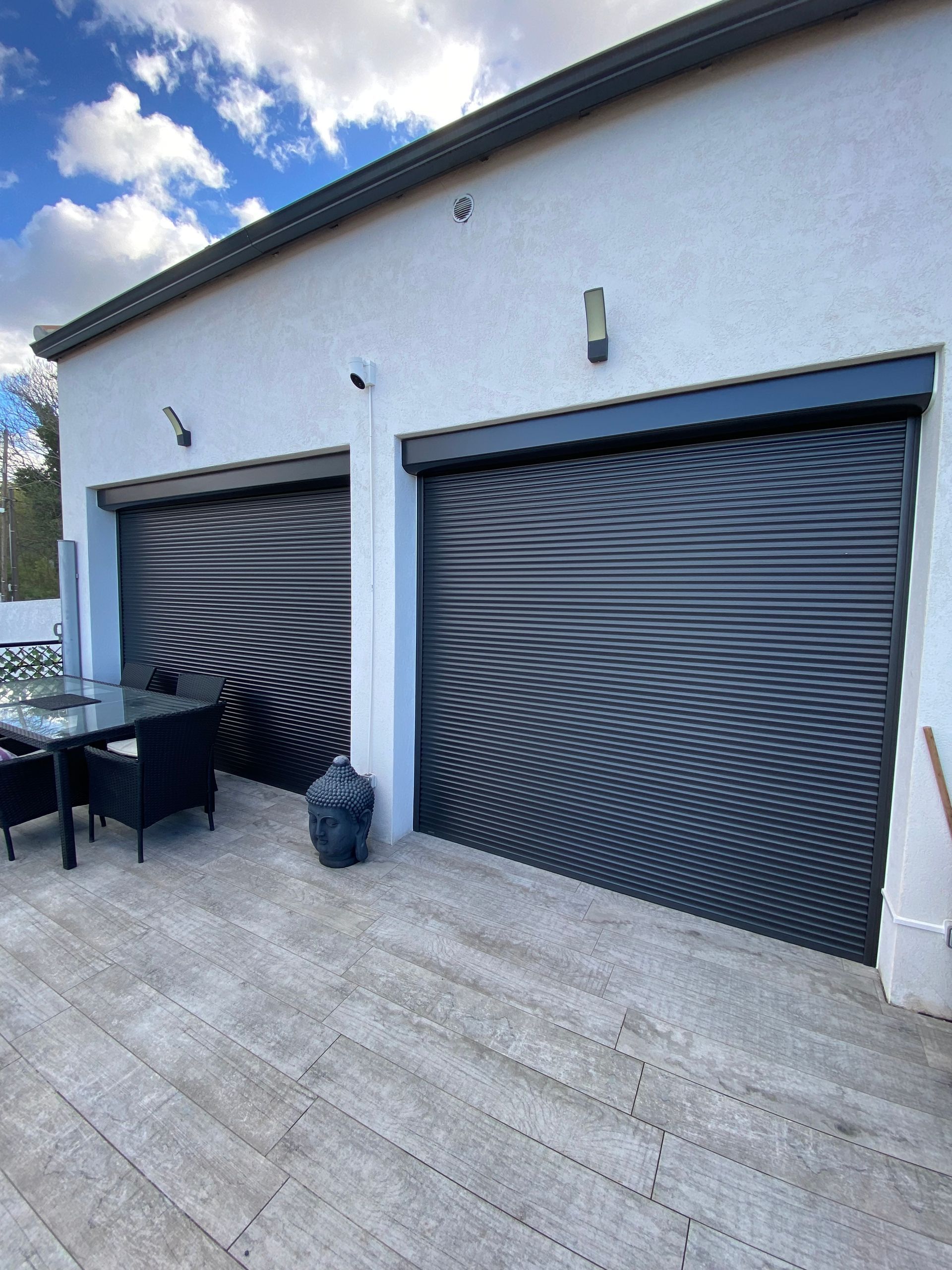 Deux grandes baies vitrées avec des volets roulants fermés