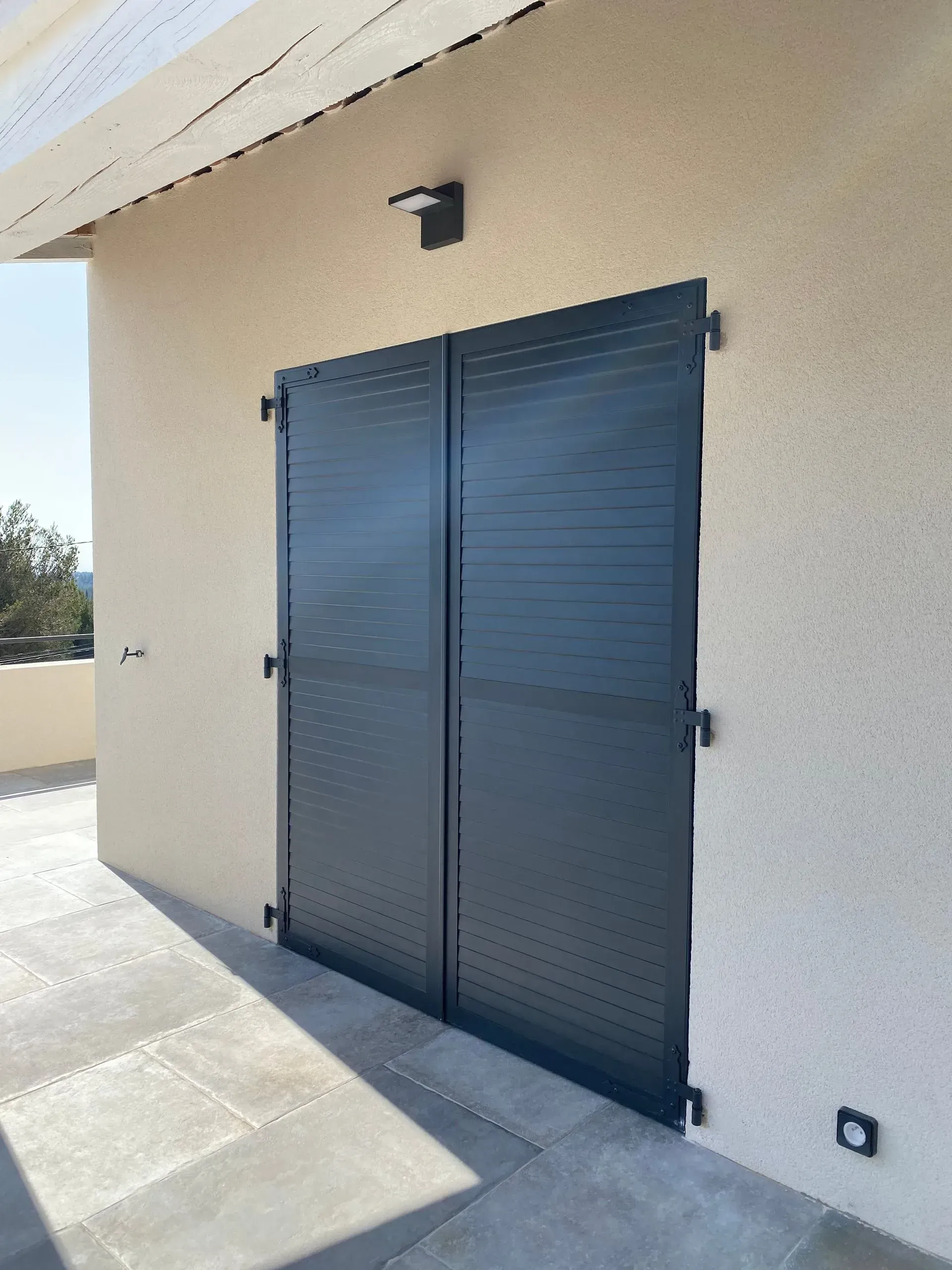 Une façade avec des volets battants fermés