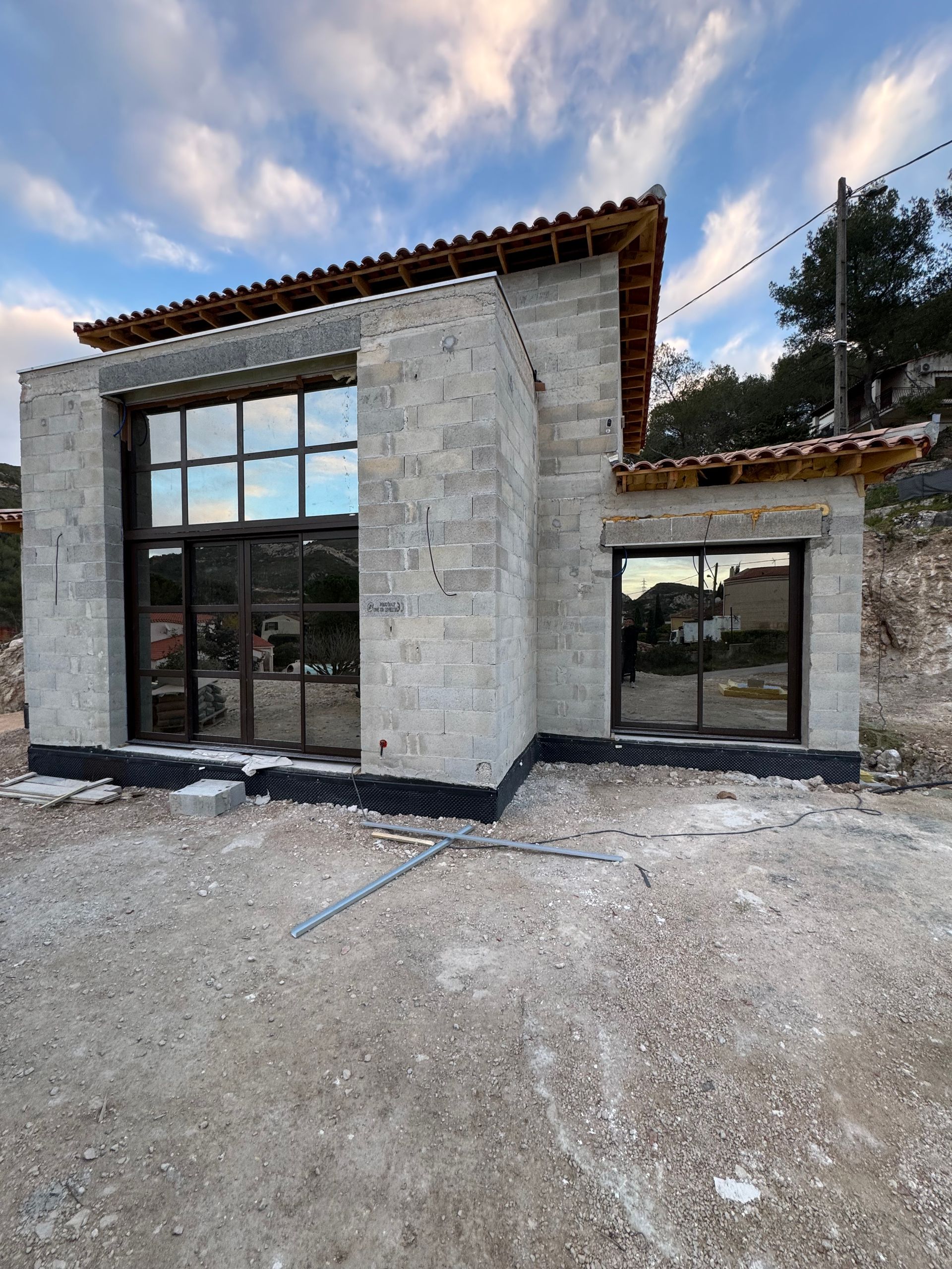 Une maison en construction avec de grandes fenêtres