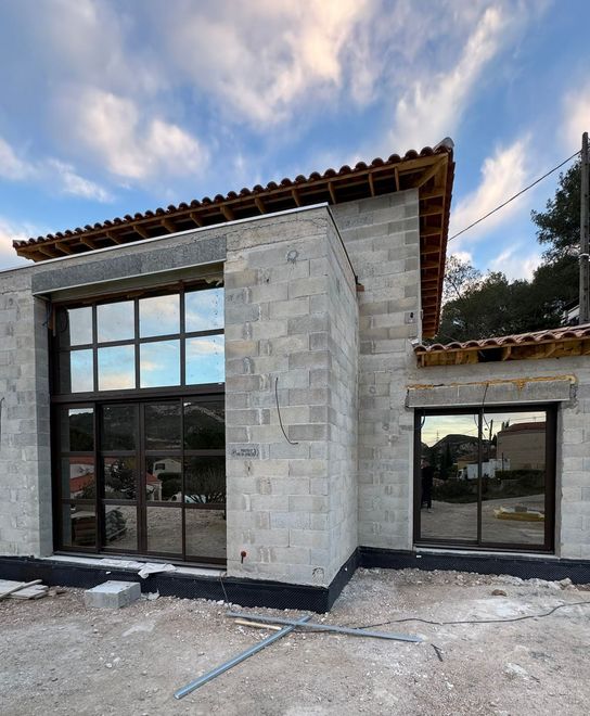 Une maison en construction avec de grandes fenêtres