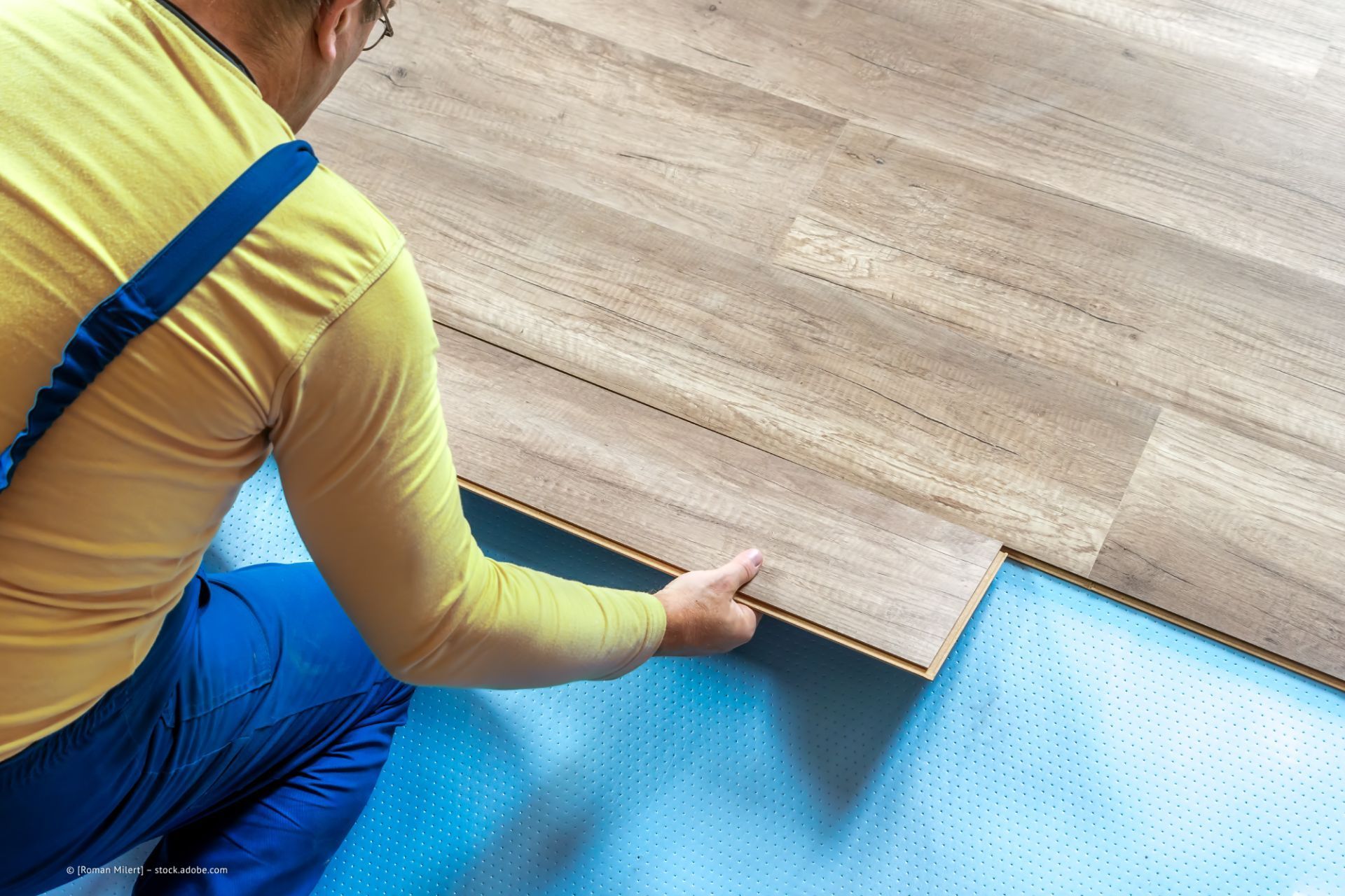 Mitarbeiter der Baltes GmbH verlegt einen Holzboden