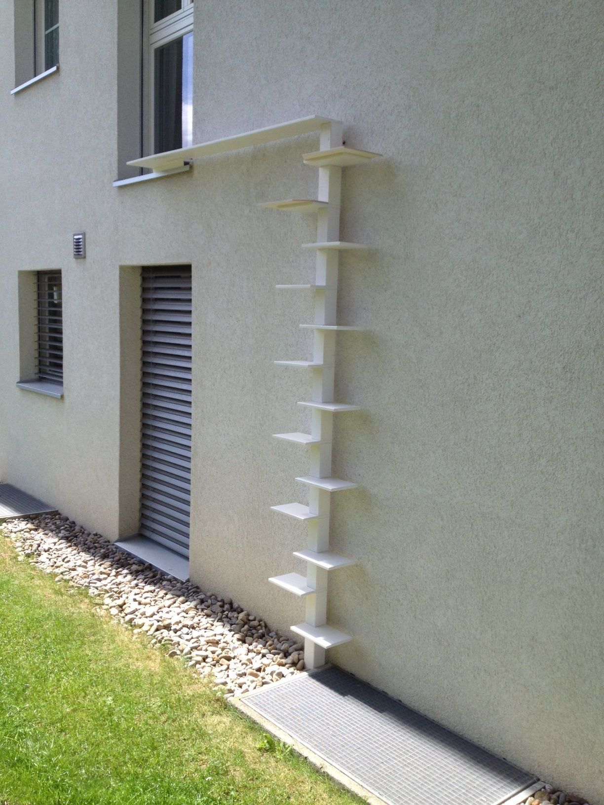 Moderne offene Küche mit Holzschränken, Backsteininsel und Treppe in einem hellen Interieur