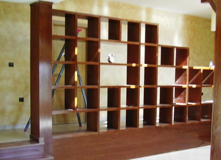 Un estante de madera con una escalera al fondo.