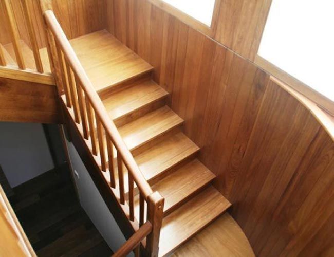 Una escalera de madera con barandilla en una casa.