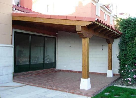 Un patio con techo de madera y puertas corredizas de vidrio.