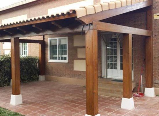 Una casa con un porche de madera y una escoba delante.