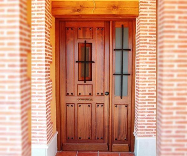 Una puerta de madera con una pared de ladrillos detrás