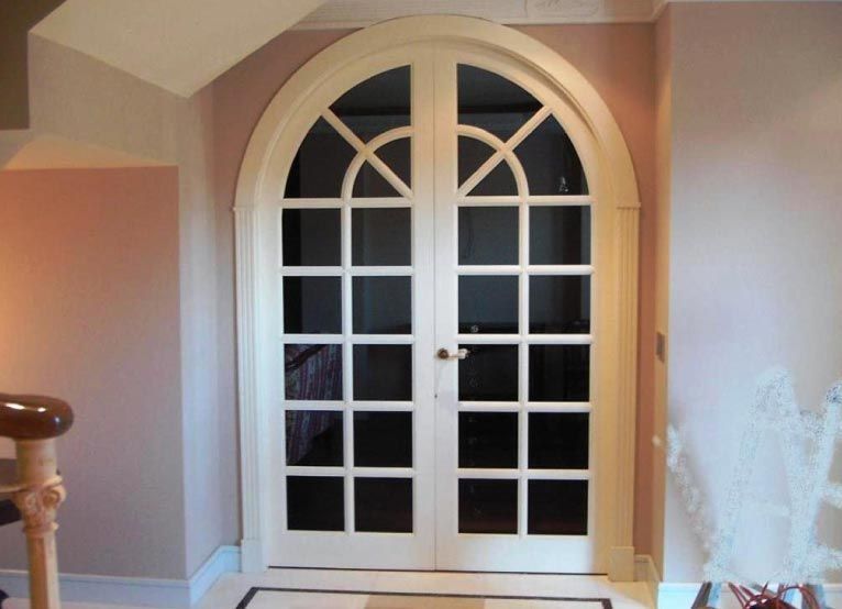 Una habitación con una escalera y una puerta blanca.