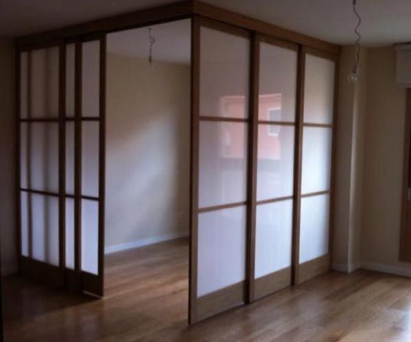 Una habitación con una puerta corrediza de vidrio entre dos habitaciones.