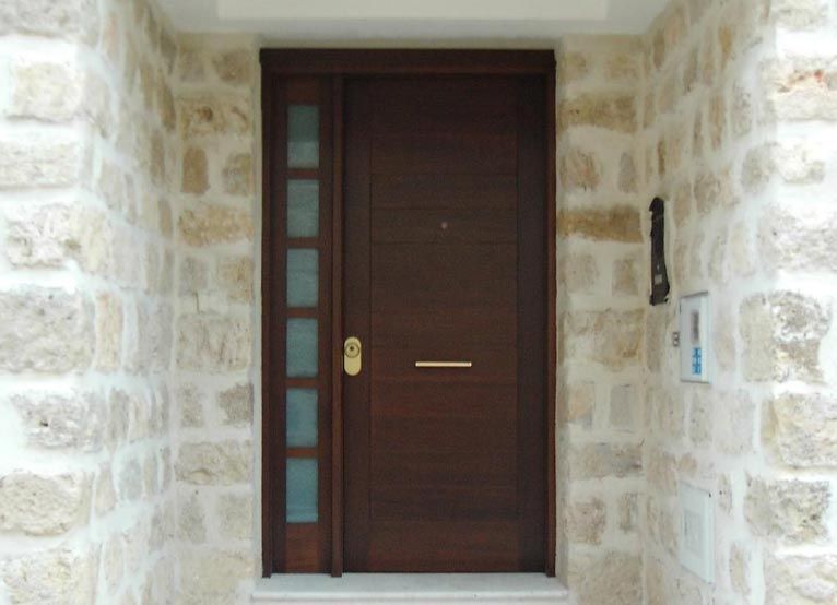 Una puerta de madera está contra una pared de piedra.