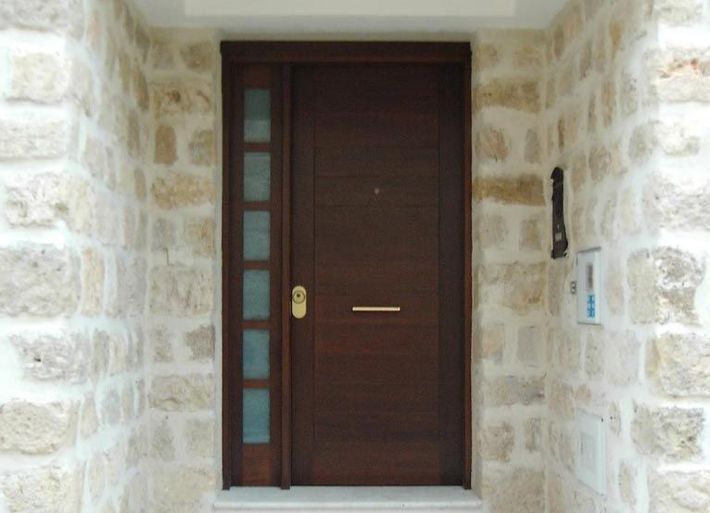 Una puerta de madera está contra una pared de piedra.