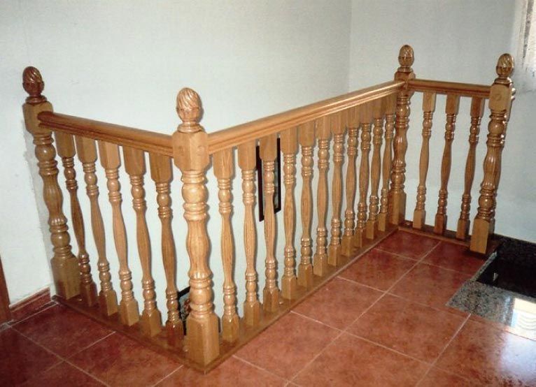 Una barandilla de madera sobre un suelo de baldosas en una habitación.