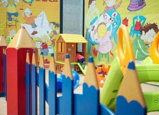 Un área de juegos para niños con una cerca que parece lápices.