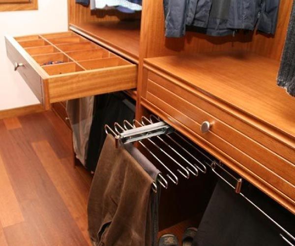 Un armario con pantalones colgando de un cajón.