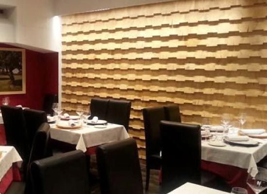 Un restaurante con mesas y sillas y una pared de madera.