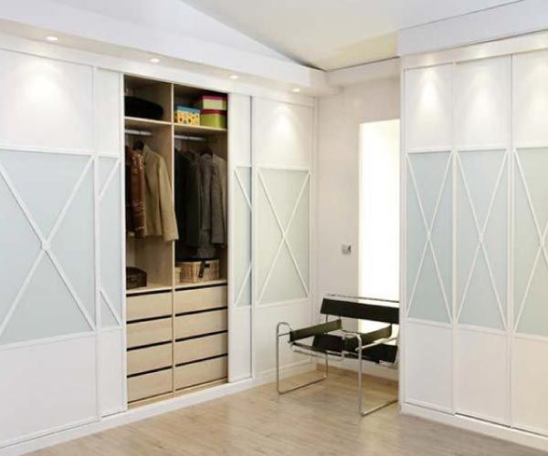 Un vestidor con puertas corredizas de vidrio y cajones.
