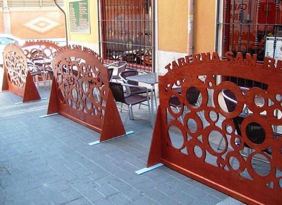 Una fila de mesas y sillas frente a un edificio con un cartel que dice taberna san r