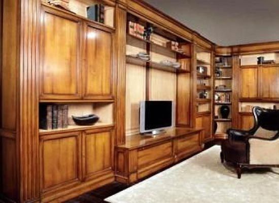 Una sala de estar con gabinetes de madera y un televisor de pantalla plana.