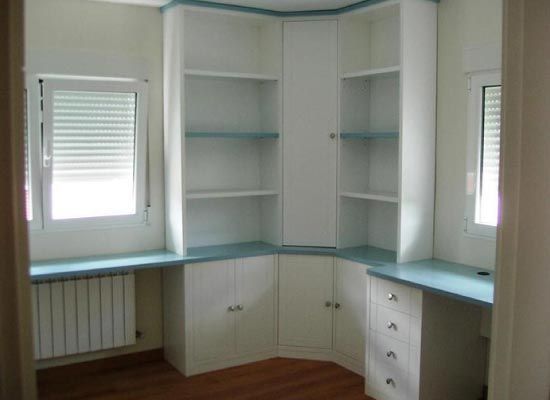 Un rincón de una habitación con estantes y una ventana.