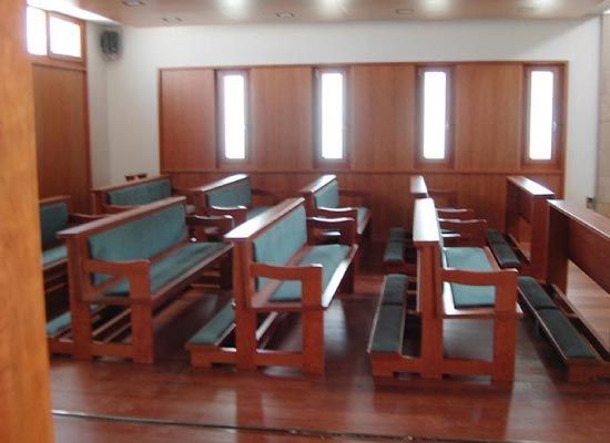 Una fila de bancos de madera en una iglesia vacía