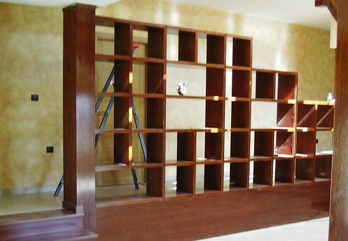 Una habitación con muchos estantes y una escalera.