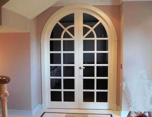 Un par de puertas de vidrio arqueadas en una habitación.
